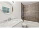 Bathroom featuring a sink with marble countertop, a round mirror, and a tiled shower and tub at 875 Waterbrook Ct, Roswell, GA 30076