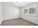 Neutral bedroom featuring plush carpeting and a window with shutter-style blinds for privacy and light control at 875 Waterbrook Ct, Roswell, GA 30076
