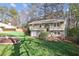 Well-maintained split-level home with stone accents, attached garage, and mature landscaping at 875 Waterbrook Ct, Roswell, GA 30076