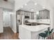 Modern kitchen features stainless steel appliances, gray cabinetry, white countertops and bar seating at 875 Waterbrook Ct, Roswell, GA 30076