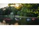People enjoying kayaks and paddleboards on the lake at sunset with community lake house and treelined shore at 875 Waterbrook Ct, Roswell, GA 30076
