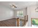 Upstairs loft space with wood-look floors, a ceiling fan, and natural light from the window at 875 Waterbrook Ct, Roswell, GA 30076