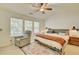 Bright bedroom featuring a comfortable bed, accent chair, and ample natural light from large windows at 2457 Birkhall Way, Lawrenceville, GA 30043