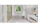 Bathroom featuring white cabinetry, a soaking tub with a window and a gold-framed shower at 486 Milledge Gate Se Ter, Marietta, GA 30067