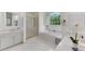 Bright bathroom featuring white cabinets, a soaking tub with window, and a glass shower at 486 Milledge Gate Se Ter, Marietta, GA 30067