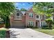 Elegant brick home featuring lush landscaping, an attached garage, and ample parking at 486 Milledge Gate Se Ter, Marietta, GA 30067