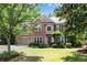 Traditional brick home featuring an attached garage, mature trees, and a well-maintained green lawn at 486 Milledge Gate Se Ter, Marietta, GA 30067