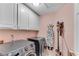 Functional laundry room features white cabinetry, modern washer/dryer, ironing board, and vacuum cleaner at 486 Milledge Gate Se Ter, Marietta, GA 30067