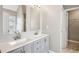 Elegant bathroom features double sinks, modern vanity and view into the walk-in closet at 5525 Mayfair Crossing Dr, Lithonia, GA 30038