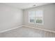 Neutrally painted bedroom with hard surface floors and a window that provides natural light at 5525 Mayfair Crossing Dr, Lithonia, GA 30038