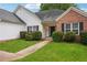 Charming single-story home with brick accents, well-manicured lawn and walkway to the front door at 5525 Mayfair Crossing Dr, Lithonia, GA 30038