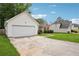 Attached two-car garage and long driveway to the side of a single-story home with white siding at 5525 Mayfair Crossing Dr, Lithonia, GA 30038