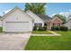 Charming single-story home with a well-manicured lawn, brick accents, and an attached two-car garage at 5525 Mayfair Crossing Dr, Lithonia, GA 30038