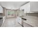 Bright kitchen featuring white cabinets, granite countertops, stainless steel appliances, and tile flooring at 5525 Mayfair Crossing Dr, Lithonia, GA 30038