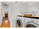 Bright laundry room features white washer and dryer, floating shelves, and hardwood floors at 69 Randolph Ne St, Atlanta, GA 30312