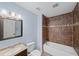 Well-lit bathroom featuring a tiled shower with decorative accents and a classic vanity at 1212 Lee Whatley Dr, Lithonia, GA 30058