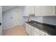 Functional laundry room with tile flooring, white cabinetry and dark countertops at 1212 Lee Whatley Dr, Lithonia, GA 30058