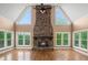Spacious living room with a stone fireplace, cathedral ceiling and large windows with wooded views at 1212 Lee Whatley Dr, Lithonia, GA 30058