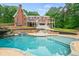 Beautiful backyard pool area with waterfall feature, gazebo, and brick house backdrop at 1212 Lee Whatley Dr, Lithonia, GA 30058