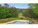 Beautiful backyard featuring a swimming pool with a slide and lush green trees at 1212 Lee Whatley Dr, Lithonia, GA 30058