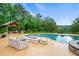 Inviting pool area with outdoor kitchen, fireplace, and comfortable seating, perfect for entertaining at 1212 Lee Whatley Dr, Lithonia, GA 30058