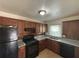 Traditional kitchen with granite countertops, wooden cabinets, and black appliances at 2069 Bixler Circle, Decatur, GA 30032