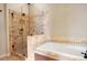 Elegant bathroom featuring a tiled shower with glass enclosure and a separate soaking tub at 2108 Waters Edge Trl, Roswell, GA 30075