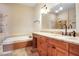 Bathroom features a soaking tub, granite counters, and warm color palette at 2108 Waters Edge Trl, Roswell, GA 30075