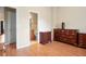 Bedroom leads to bathroom and has hardwood floors and wooden dressers at 2108 Waters Edge Trl, Roswell, GA 30075