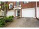 Brick townhome featuring a garage, classic architectural details, and manicured landscaping at 2108 Waters Edge Trl, Roswell, GA 30075