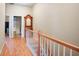 Hallway with wood floors, wood and white railing, and view to the laundry area at 2108 Waters Edge Trl, Roswell, GA 30075