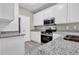 Well-lit kitchen featuring white cabinets, granite countertops, stainless steel appliances, and gray flooring at 3302 Dogwood Dr # 123, Atlanta, GA 30354