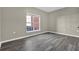 Sunlit living room with gray laminate flooring, neutral walls, and white trim at 3302 Dogwood Dr # 123, Atlanta, GA 30354