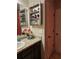 Bathroom with granite countertop, dark cabinets, matching medicine cabinets, and a door to the side at 7848 Rock Rose Ln, Fairburn, GA 30213