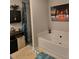 Bright bathroom with a soaking tub, shower with blue curtain, and beach themed decor above the bathtub at 7848 Rock Rose Ln, Fairburn, GA 30213