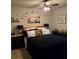 Neutral bedroom with a ceiling fan, dark furnishings, and decorative artwork above the bed at 7848 Rock Rose Ln, Fairburn, GA 30213