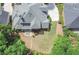 An aerial view of the home showcases the spacious yard, mature trees, and charming patio area at 9175 Etching Overlook, Johns Creek, GA 30097