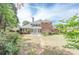 Expansive brick home featuring a patio, landscaped yard, and lush greenery at 9175 Etching Overlook, Johns Creek, GA 30097