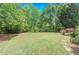 Manicured lawn is surrounded by trees with a stone path on one side at 9175 Etching Overlook, Johns Creek, GA 30097