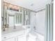 Traditional bathroom features a shower and tub combo, patterned wallpaper, and a vanity sink at 9175 Etching Overlook, Johns Creek, GA 30097