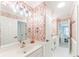 Well-lit bathroom featuring unique floral wallpaper, white vanity, and adjoining bedroom views at 9175 Etching Overlook, Johns Creek, GA 30097