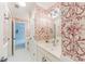 Elegant bathroom with bright floral wallpaper, white vanity with a large mirror, and modern lighting at 9175 Etching Overlook, Johns Creek, GA 30097