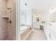 The bathroom features a tiled stand-up shower, a tub, and a vanity with double sinks at 9175 Etching Overlook, Johns Creek, GA 30097