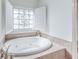 Well-appointed bathroom featuring a soaking tub with jets and a decorative window for natural light at 9175 Etching Overlook, Johns Creek, GA 30097