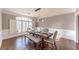Bright dining room boasts hardwood floors, modern lighting, and window with plantation shutters at 9175 Etching Overlook, Johns Creek, GA 30097