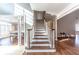 Entryway with staircase, wood flooring, and bright open floorplan, leading to a dining room and living areas at 9175 Etching Overlook, Johns Creek, GA 30097
