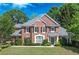 Charming two-story brick home featuring a manicured lawn and mature trees in a lovely residential setting at 9175 Etching Overlook, Johns Creek, GA 30097