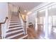 Stairway in open foyer showcases hardwood floors and views into the living room at 9175 Etching Overlook, Johns Creek, GA 30097