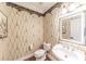 Charming half bathroom with elegant wallpaper and vanity at 9175 Etching Overlook, Johns Creek, GA 30097