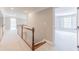 Hallway view with stairs and entry to a bedroom with a window and white shutters at 9175 Etching Overlook, Johns Creek, GA 30097
